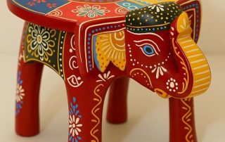 Hand-painted wooden elephant-shaped small bedside table with colorful floral designs.